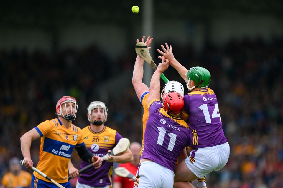 Clare's John Conlon, left, and Wexford's Cathal Dunbar look on as their teammates Lee Chin, 11, and Conor McDonald contest a dropping ball during this year's All-Ireland SHC quarter-final. Photo: Ray McManus/Sportsfile