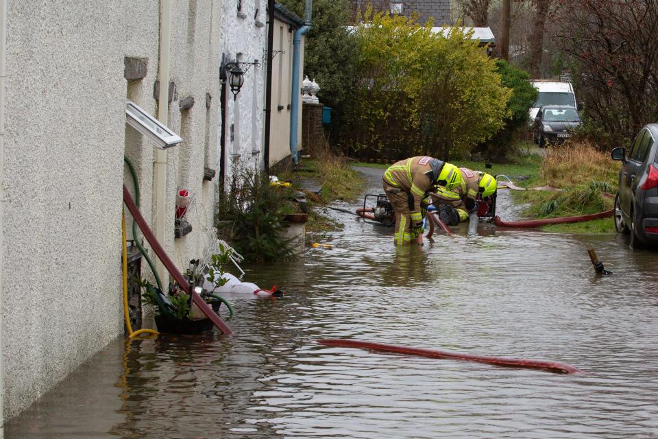 Pontrhydfendigaid, Ceredigion, Wales, UK. 07th December 2024 UK Weather: Mid & West Wales Fire crew pumping away flooded water that is encroaching into residents’ properties in the rural village of Pontrhydfendigaid, as strong winds from Storm Darragh continues throughout the day. © Ian Jones/Alamy Live News