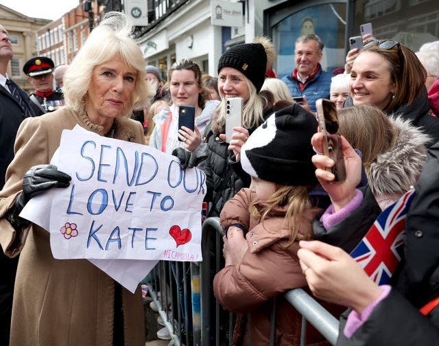 Camilla holding a sign that reads 'send our love to Kate' that she received from well-wishers during a visit to Shrewsbury