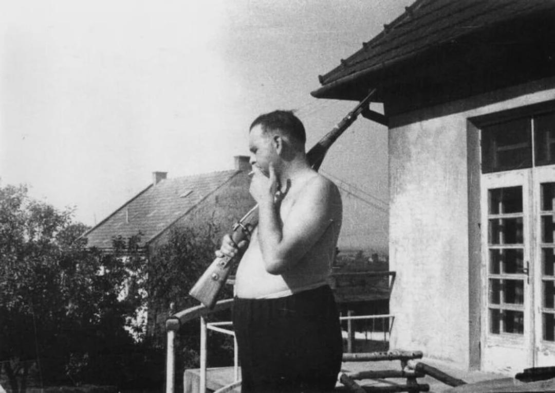 Kraków-Płaszów Camp Commandant Amon Göth standing on his balcony preparing to shoot prisoners, Poland, 1943.