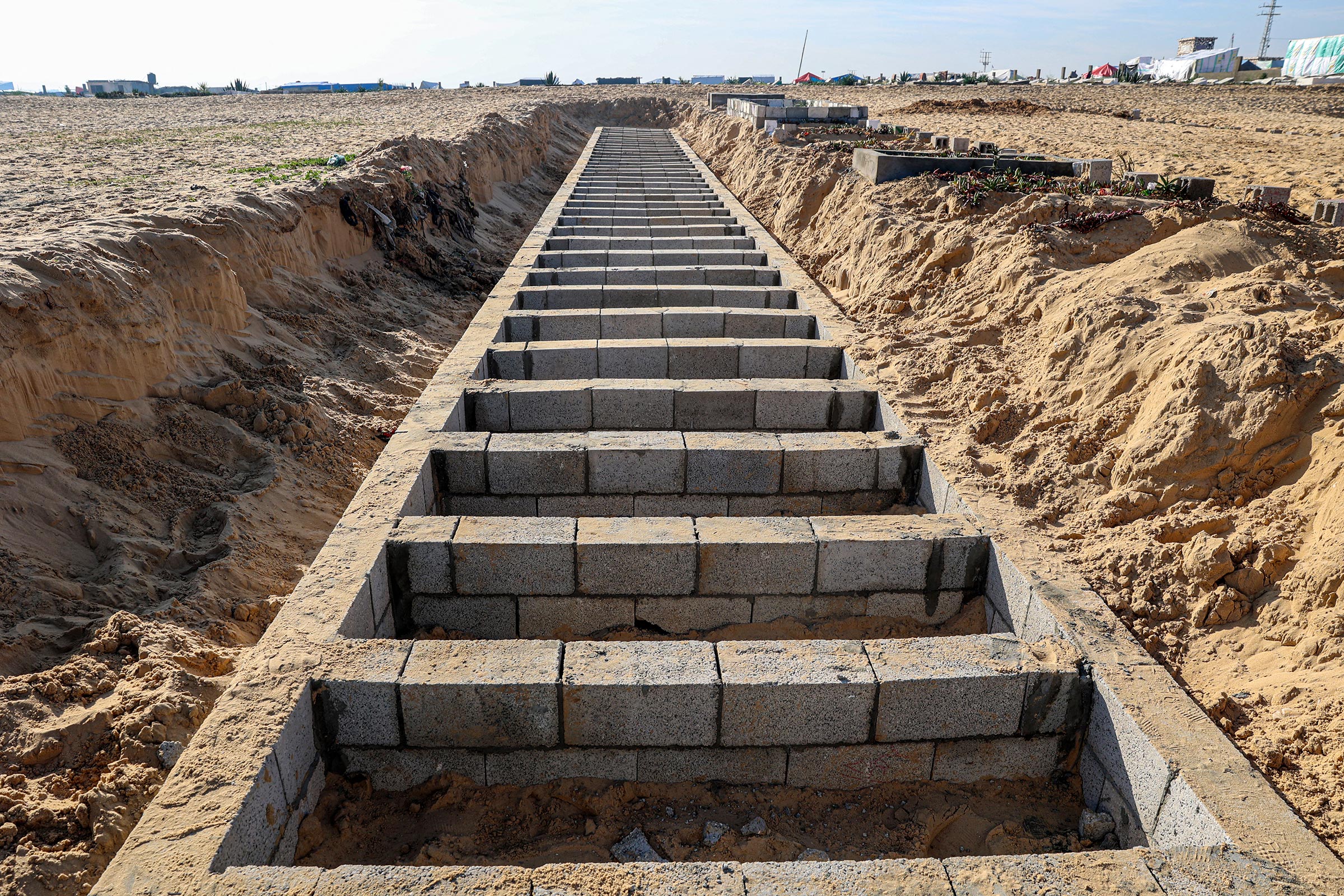 Graves are prepared for the funeral of Palestinians killed in overnight Israeli strikes at a cemetery in Rafah, on the southern Gaza Strip on Feb. 21, 2024.