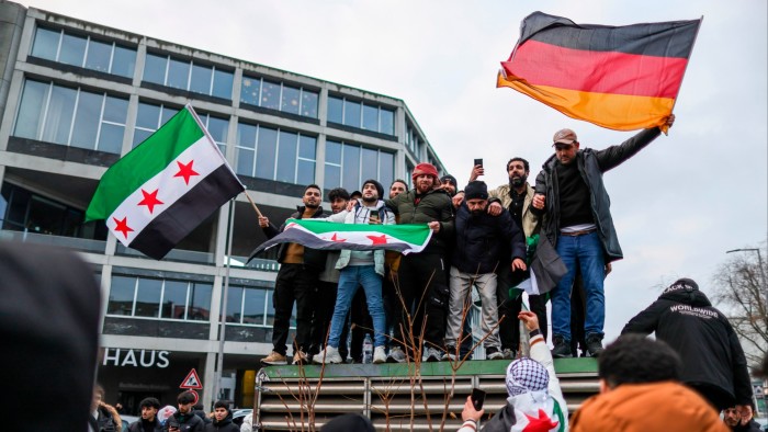 Expatriate Syrians gather with flags in Berlin on Sunday to celebrate the fall of the Assad regime