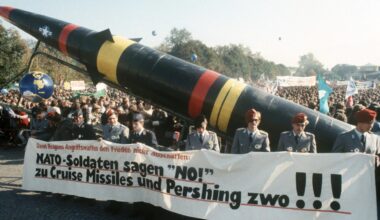Soldaten der Bundeswehr in Uniform laufen mit einem Transparent und einer Pershing-II-Attrappe bei einer Demonstration gegen die NATO-Hochrüstung.