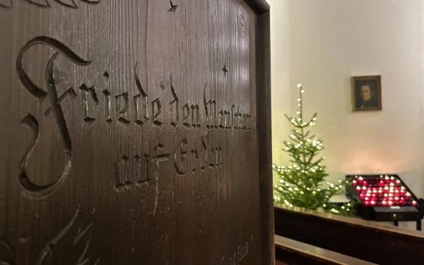Candles burn behind the entrance to the Silent Night Chapel in December 2024. About 60,000 visitors from around the world come to Oberndorf annually to see the birthplace of 