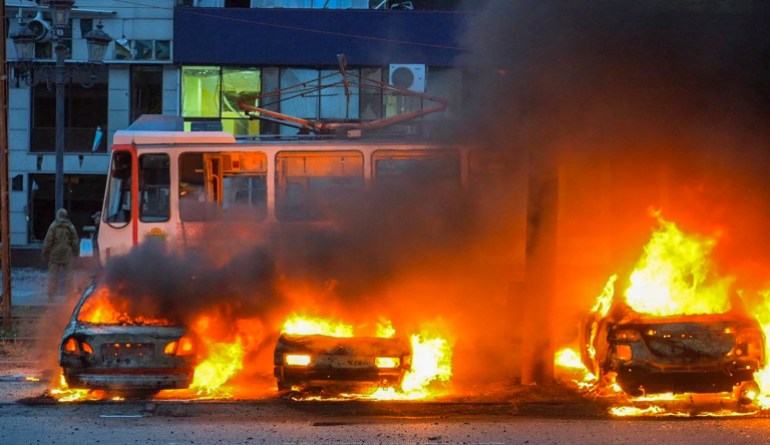 burning cars in front of a tram