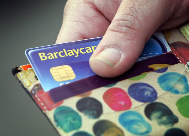 A Barclays Bank's customer takes out a bank card in London February 21, 2006. Barclays Plc, Britain's third-biggest bank, said on Tuesday profits jumped 15 percent to a record last year, just beating analysts' forecasts as higher investment banking income offset a big rise in bad debts. Expansion in the bank's international business easily outpaced domestic growth, where it is struggling to turn around the Woolwich mortgage business and lost further market share. REUTERS/Stephen Hird