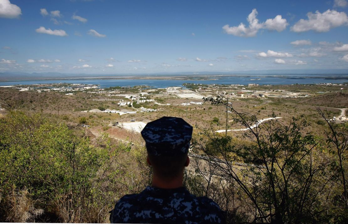 In this file image reviewed by the US military, a US Navy sailor looks out over the US Naval Base at Guantanamo Bay, Cuba.