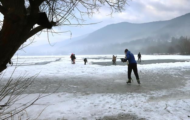 Ice skaters and ice-hockey players on the frozen Môťová water reservoir near Zvolen, central Slovakia.