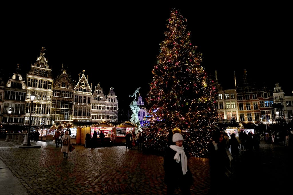 People walk around a tree at a Christmas market in the historical centre of Antwerp, Belgium, in December. Photo: AP People walk around a tree at a Christmas market in the historical centre of Antwerp, Belgium, in December. Photo: AP