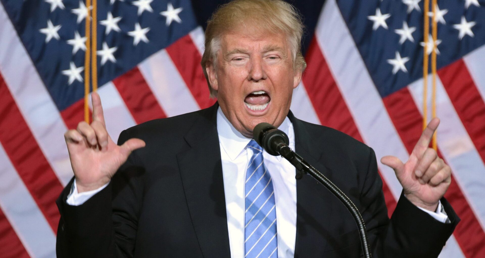 Donald Trump giving a speech with his hands either side of his face