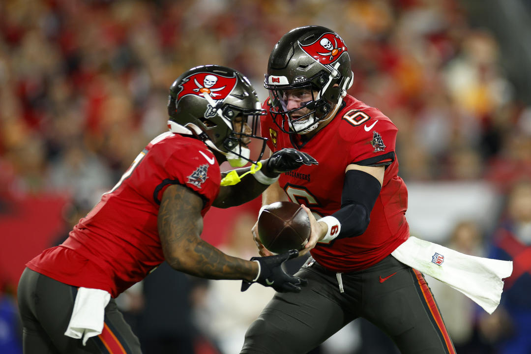 TAMPA, FLORIDA - JANUARY 12: Baker Mayfield #6 of the Tampa Bay Buccaneers hands the ball to Bucky Irving #7 against the Washington Commanders during the first quarter in the NFC Wild Card Playoff at Raymond James Stadium on January 12, 2025 in Tampa, Florida. (Photo by Mike Ehrmann/Getty Images)