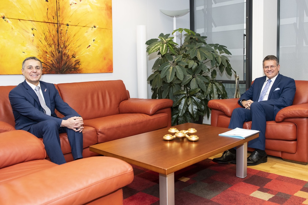 two men sitting on sofas in suits