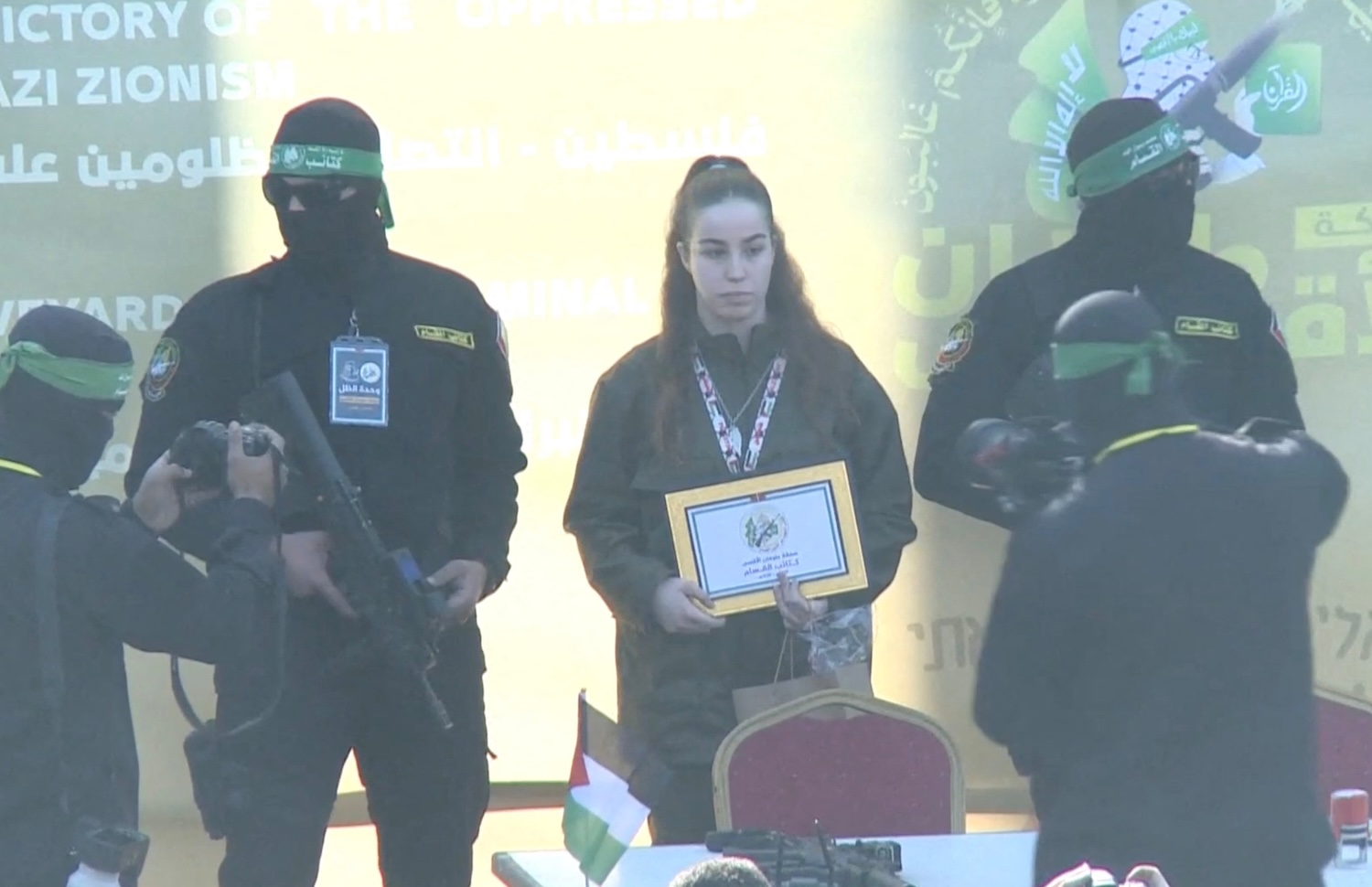 Hamas militants flank Israeli soldier Agam Berger, held in Gaza since the Oct 7, 2023 attack, following her release in Jabalia in the northern Gaza Strip on Thursday morning. More hiostages, including five Thais, were expected to follow. (Photo: Reuters)