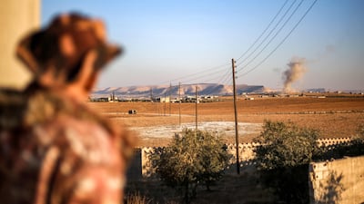 A Turkish-backed Syrian National Army fighter watches smoke rising from a bombardment near Manbij, in Aleppo province, amid battles with the Kurdish-led Syrian Democratic Forces. AFP