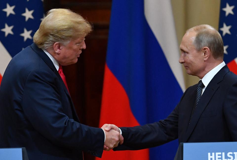 Donald Trump and Vladimir Putin shake hands after a conference in Helsinki, 2018 (AFP via Getty Images)