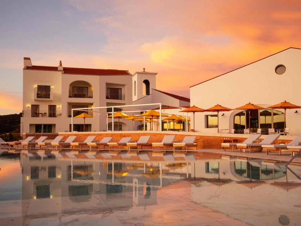 A modern resort poolside area at sunset