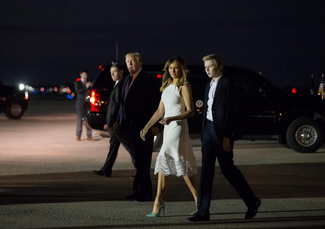 President Donald Trump, first lady Melania Trump and son Barron Trump walk toward the crowd gathered at Palm Beach International Airport in West Palm Beach, Fla., Tuesday, Nov. 20, 2018.