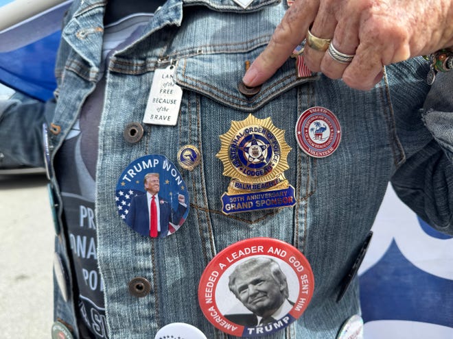 Mary Kelley shows her buttons and pins on the bridge to Palm Beach near Mar-a-Lago on Dec. 12, 2024 in Palm Beach, Fl.