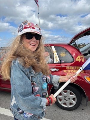 Mary Kelley known to her friends as “MAGA Mary,” waves flags from her car on the bridge to Palm Beach near Mar-a-Lago on Dec. 12, 2024 in Palm Beach, Fl.