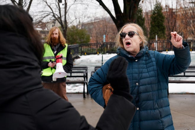 A woman heckles protestors during a protest against president-elect Donald Trump’s inauguration Saturday in Cincinnati's Washington Park.