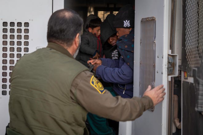 Immigrants prepare to be transported by the U.S. Border Patrol after crossing the U.S.-Mexico border on January 20, 2025 near Sasabe, Arizona. Immigrant families had passed through a gap in the Trump-built border wall hours before Donald J. Trump was inaugurated for a second time as President of the United States.