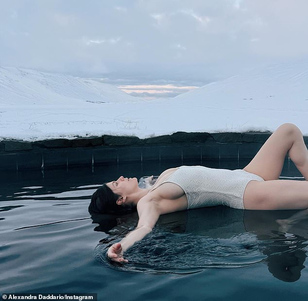 Alexandra Daddario flaunted her post-baby body in a white one-piece swimsuit while relaxing in a hot tub during her New Year's getaway to Iceland on Thursday just two months after welcoming her first child