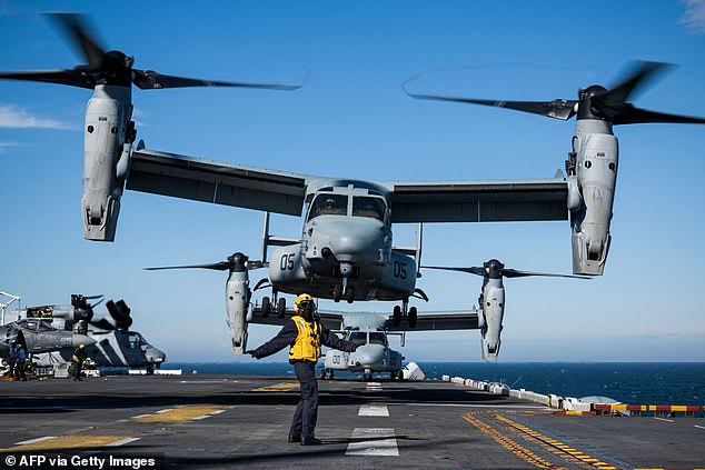 Aviation Boatswain's Mate signals to the pilots of the MV-22 Osprey assault support aircraft, assigned to 22nd Marine Expeditionary Unit, as it departs off the flight deck of the Wasp-class amphibious assault ship USS Kearsarge (LHD 3) on June 8, 2022