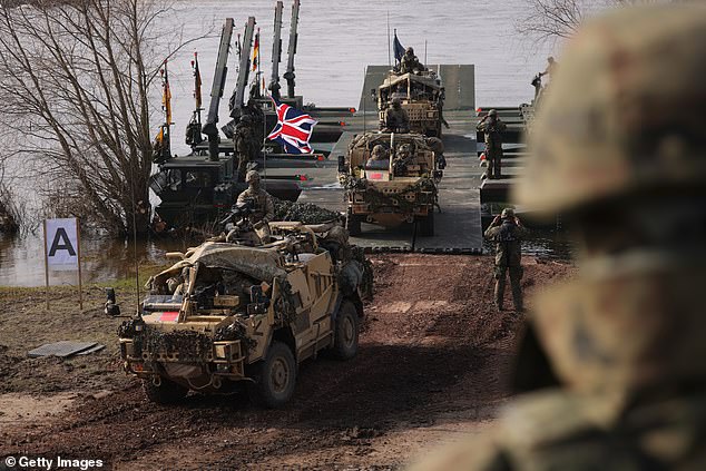 British troops driving Jackal combat vehicles descend from M3 amphibious rigs of the German/British Amphibious Engineer Battalion 130 after crossing the Vistula River during the NATO Dragon 24 military exercise on March 4, 2024