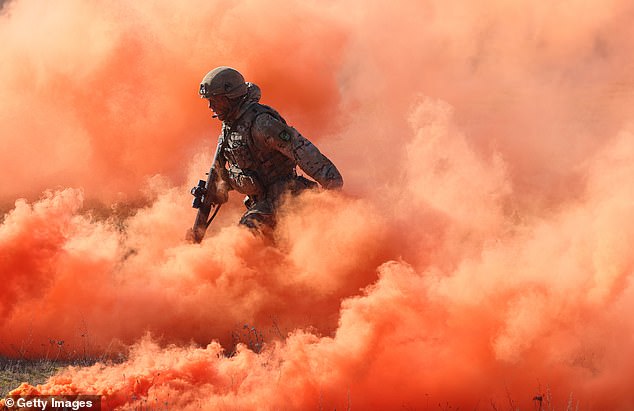 A soldier of the United Kingdom's 2nd Battalion Royal Anglian infantry unit storms an enemy position in a simulated attack during the NATO "Brilliant Jump" military exercises on February 26, 2024 in Drawsko Pomorskie, Poland