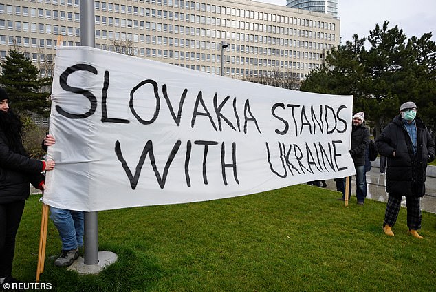 People hold a banner, as demonstrators attend an anti-government protest, after Slovak Prime Minister Robert Fico met with Russian President Vladimir Putin in Moscow, amid Russia's attack on Ukraine