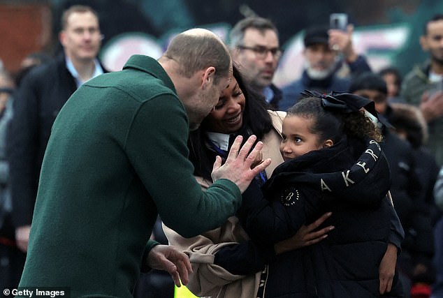 Prince William, Prince Of Wales stands with Tiber Chairperson Cherise Smith while meeting a child