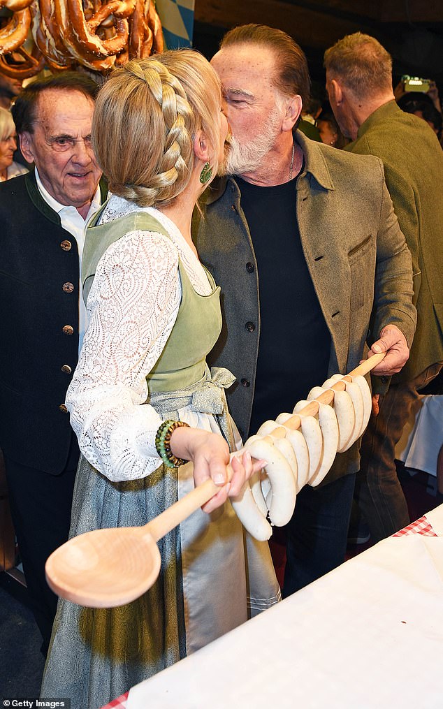 While at a recent Bavarian celebration Arnold enjoyed a cheeky kiss with a traditionally dressed blonde woman