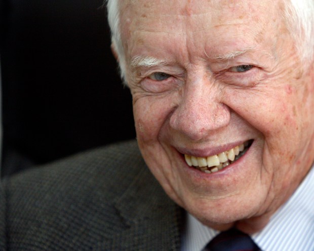 The late Former U.S. President Jimmy Carter smiles during a meeting with Sudanese officials at the national elections commission in Khartoum, Sudan, April 9, 2010. (AP Photo/Amr Nabil, File)