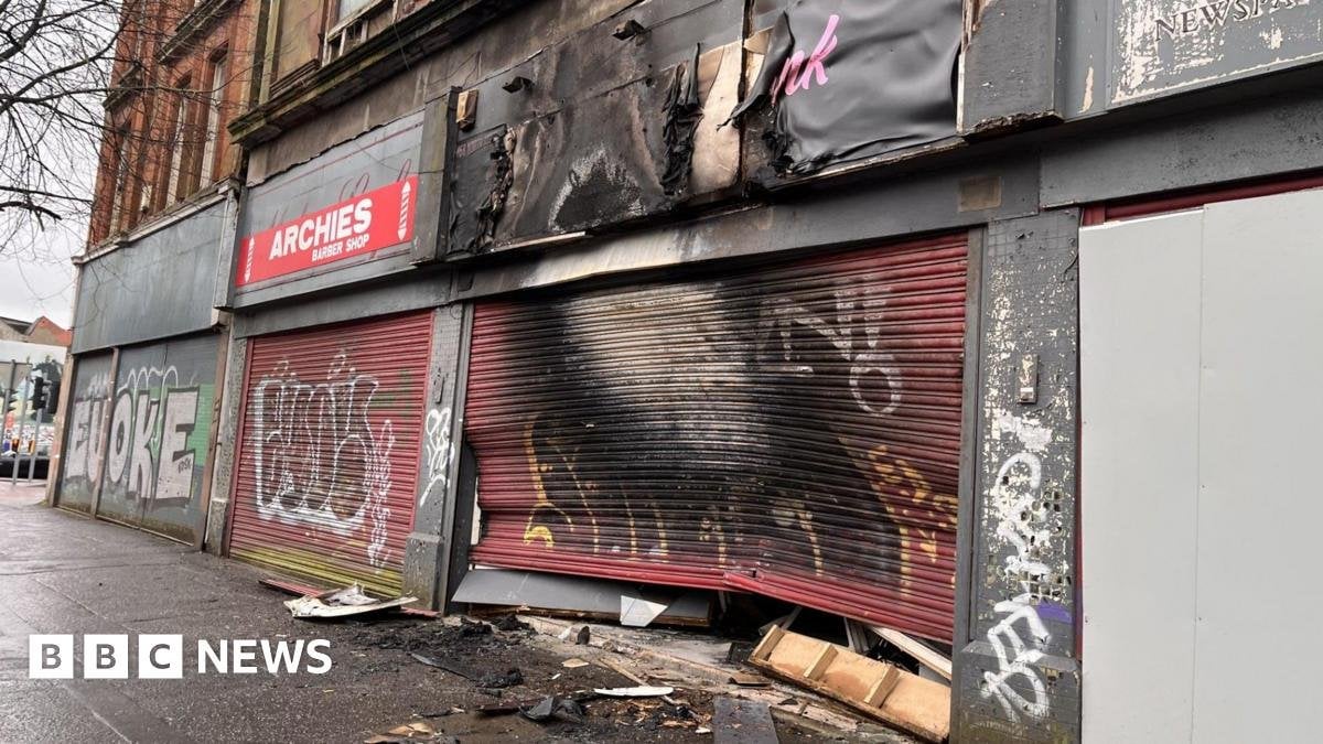 Salon owner 'devastated' by suspected arson attack A shop front with red shutters is caved in with significant fire damage visible with black and white marks across it.