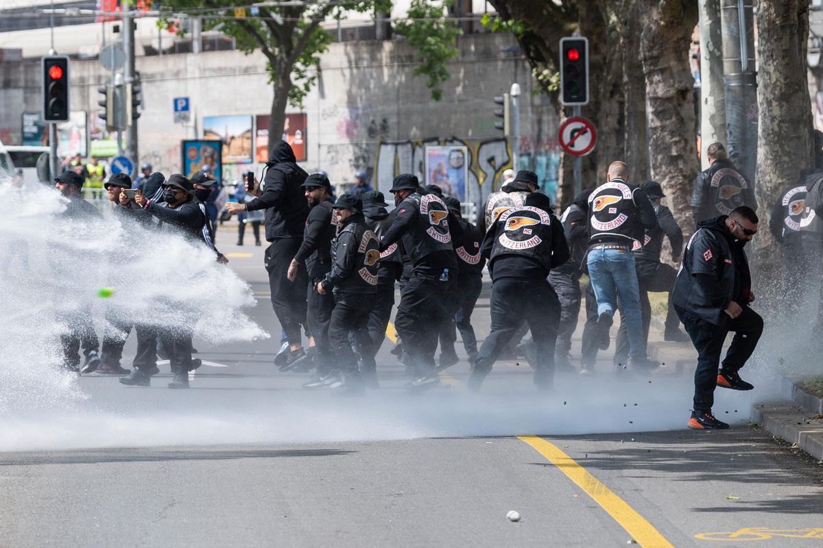 Mitglieder von Motorradclubs wie Hells Angels, Broncos und Bandidos stehen in Bern, umgeben von Rauch und Wasser. Datum: 30.05.2022. Foto von Raphael Moser.