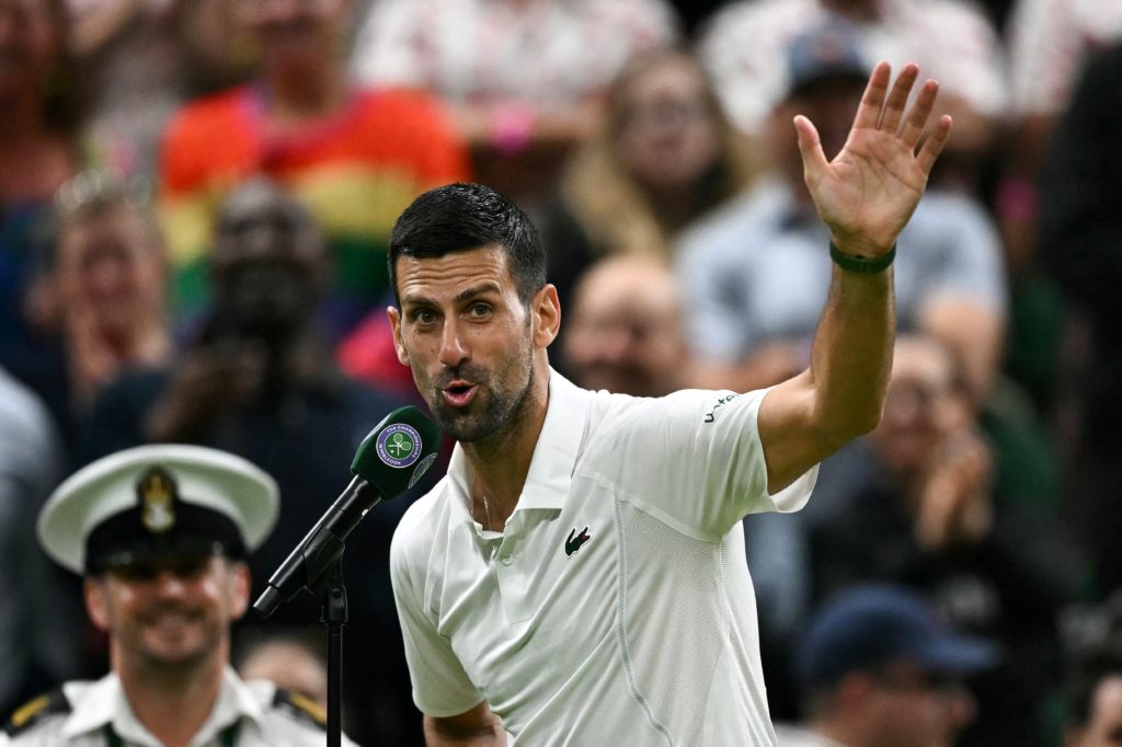 Winner Serbia's Novak Djokovic speaks during an interview and reacts to the cheering of the crowd at the end of his men's singles tennis match agai...