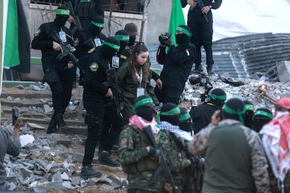Milicianos de Hamas trasladan entre edificios en ruina en Jabalia, Gaza, a la soldada para ser entregada al equipo de la Cruz Roja.