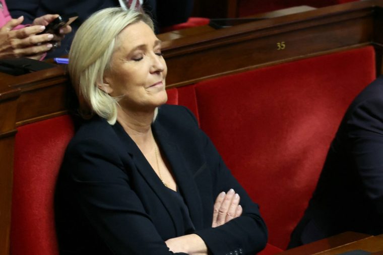 TOPSHOT - President of Rassemblement National parliamentary group Marine Le Pen reacts during the debate prior to the no-confidence votes on Prime Minister Michel Barnier's administration at the National Assembly in Paris on December 4, 2024. The French National Assembly debates two motions brought by the French left-wing Nouveau Front Populaire (New Popular Front) NFP coalition and the French far-right Rassemblement National (National Rally) RN party in a standoff over 2025's austerity budget, which saw French Prime Minister force through a social security financing bill without a vote (article 49.3) on December 2, 2024. (Photo by Alain JOCARD / AFP) (Photo by ALAIN JOCARD/AFP via Getty Images)