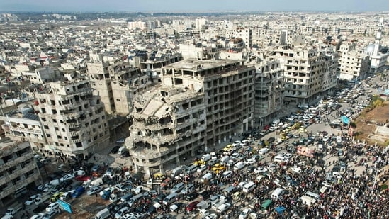 This aerial photo shows Syrians gathering near a destroyed building in the central city of Homs as they celebrate the fall of Bashar al-Assad's iron-fisted rule. (AFP)