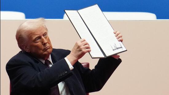 US President Donald Trump holds up an executive order. (Getty Images via AFP)