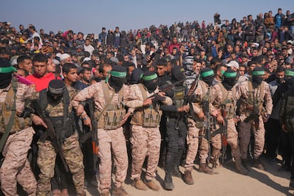 Milicianos de Hamás y de la Yijad Islámica intentan contener a los palestinos que presencian el traspaso a la Cruz Roja de los rehenes israelíes Gadi Mozes y Arbel Yahoud.