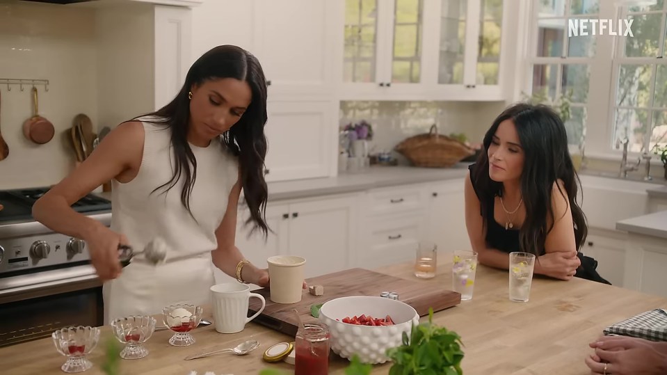 Meghan Markle and a friend preparing desserts in a kitchen.