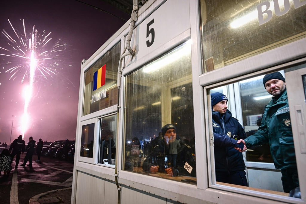 Romanian and Bulgarian police officers shake hands at a check point. Phot: AFP Romanian and Bulgarian police officers shake hands at a check point. Phot: AFP