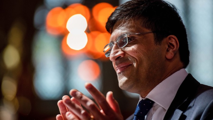 Nikhil Rathi, pictured from the side, with his hands together as he speaks
