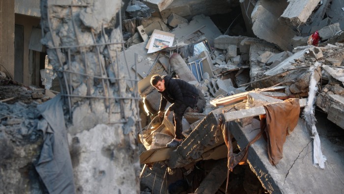 People search the rubble of a building destroyed in an Israeli strike on the Bureij camp for Palestinian refugees in the central Gaza Strip