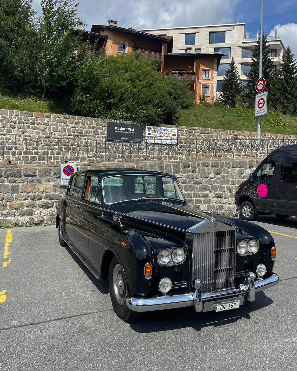 classic black rollsroyce parked in an urban setting with buildings in the background