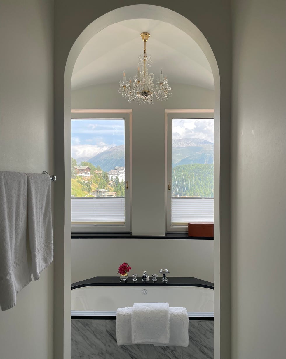 luxurious bathroom with mountain views featuring a chandelier and a bathtub