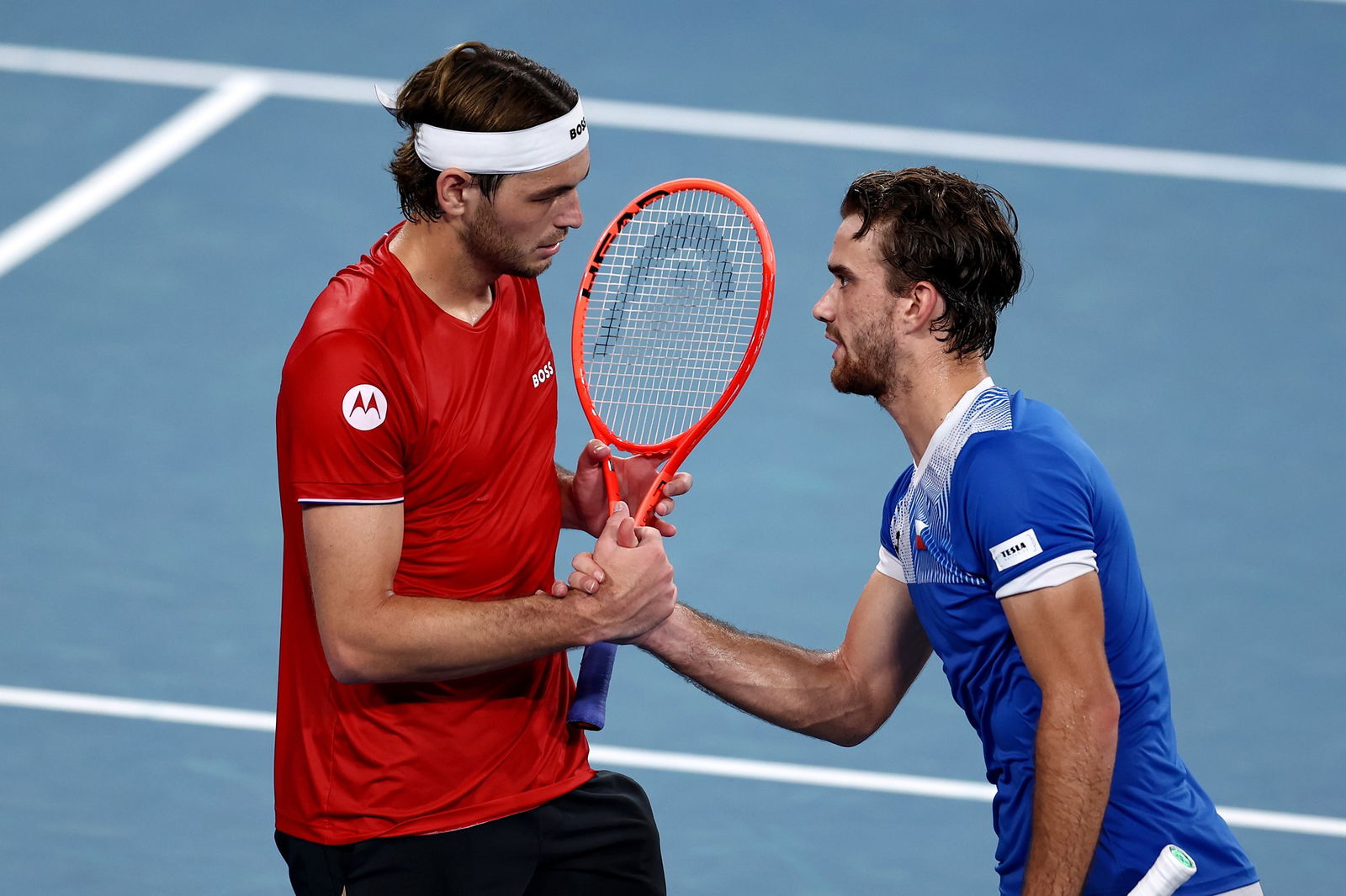Tomáš Macháč shakes hands with Taylor Fritz .