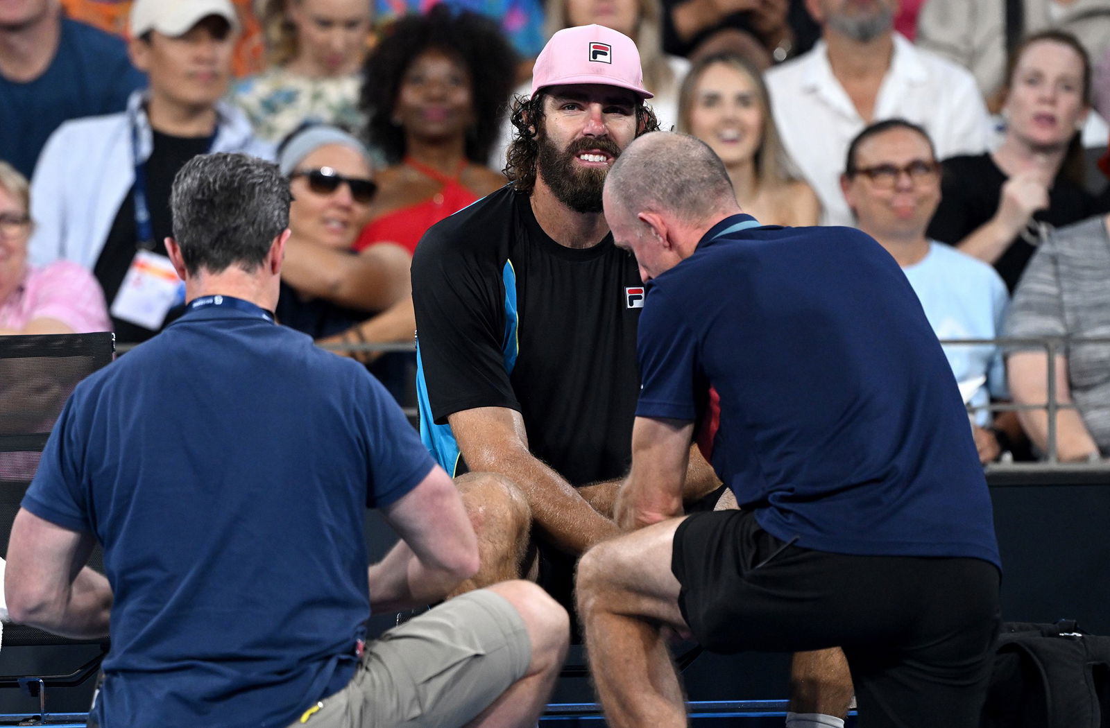 Reilly Opelka receives treatment from a physio.