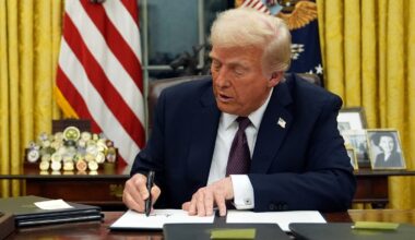 President Donald Trump signs an executive order in the Oval Office of the White House